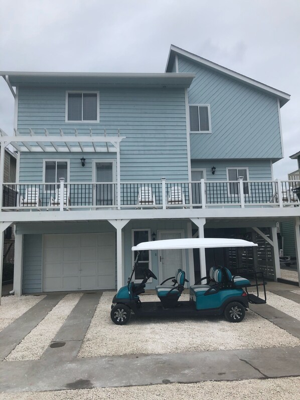 Front view of the home along with golf cart included with weekly rental