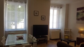 Salon avec canapé confortable et grand téléviseur LCD à écran plat.