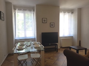 Salle à manger et salon très lumineux donnant sur la place principale du village