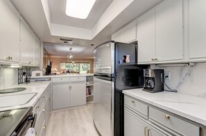 Converse with guests while working in the kitchen. Open concept, coastal style