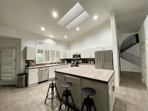 A spacious kitchen features stainless steel appliances and a large island