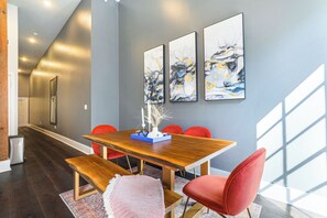 Open-concept living, kitchen, and dining area with ample seating. 65” Samsung Smart 4K TV with streaming and DIRECTV Entertainment. Sofa converts to a queen sleeper. Dining table seats four. Enjoy plenty of natural light!
