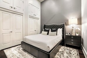 Spacious guest bedroom with a queen bed and designer closet. Includes a nightstand, lamp, hangers, luggage rack, alarm clock, white noise machine, and a 50'' Samsung Smart 4K TV for streaming your favorite apps with DIRECTV Entertainment.