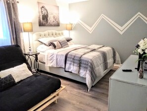 Master bedroom with queen. bed, futon bed, and attached half bath.