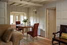 Spacious open-plan sitting and dining room with characterful panelled walls.