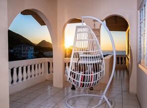 Private balcony with mountain and ocean view. Swing for relaxation and comfort.