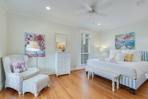 - Spacious bedroom blends comfort & charm with striped bed frame & sunny accent pillows - Reading chair & cheerful art bring a playful, relaxed vibe to this coastal escape - Natural light pours in through tall windows, brightening the space