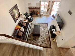 Living room with leather recliner sofa, 55 inch smart TV, fireplace.