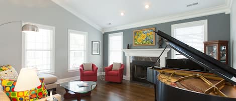 living room with grand piano and gas fireplace
