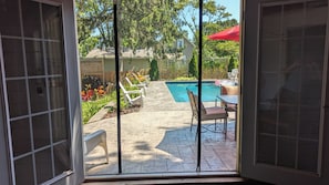 Pool house with french doors opening to the patio and pool