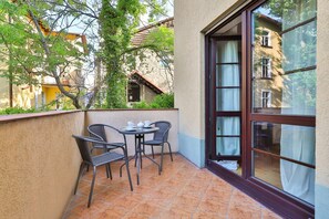 Spacious balcony with outdoor furniture. 