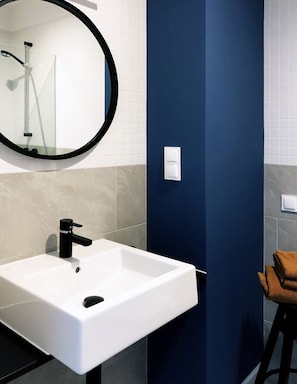 Bright bathroom with washing machine and shower cabin.
