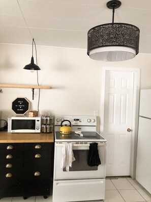 View of kitchen with stove, pantry (through the door) and fridge