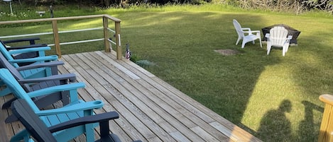 small porch with comfy chairs, fire pit and a nice view of the bay