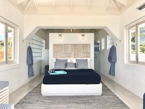 The queen size bed from the main bedroom. The bathroom is behind the bed wall.
