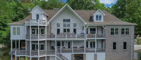 Back of lakefront house 2 covered decks and balcony.  Plenty of seating