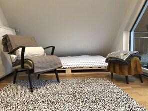 Low-profile platform bed in sunroom between bedroom & balcony