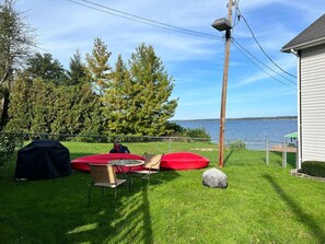 Lakeside lawn with kayaks and plenty of space to relax or play.