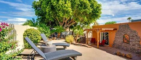 Backyard patio with sun loungers, hot tub, gas chiminea, and BBQ