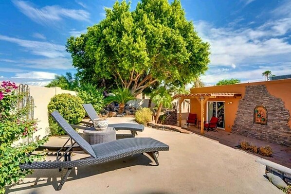 Backyard patio with sun loungers, hot tub, gas chiminea, and BBQ