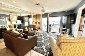 The large glass sliding door takes center stage in the living room with a wall mounted TV in the corner.