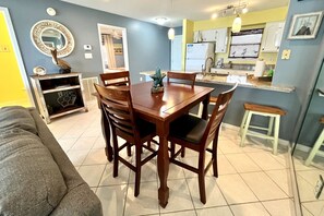 The dining area with table, chairs, & adjacent bar seating.