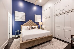 Spacious master bedroom with king-size bed, ensuite bathroom, and designer built-in closets. Equipped with lamps, hangers, luggage racks, alarm clock, white noise machine, and a 50'' Samsung Smart 4K TV with streaming and DIRECTV Entertainment.