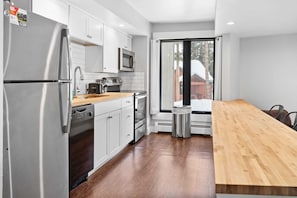 The beautifully renovated kitchen features stainless steel appliances, butcher block counters, and a kitchen bar with 4 bar stools.