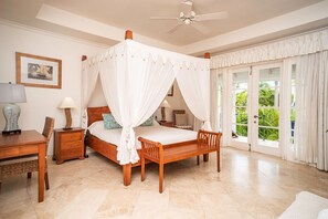 The spacious and bright master bedroom with a king bed, patio, air-conditioning and en suite