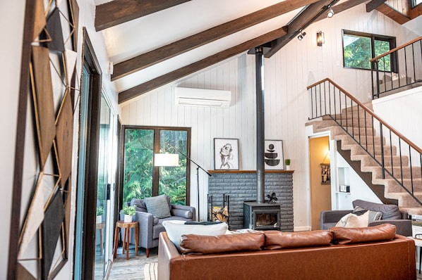 Tall ceiling with wood beams throughout. Walls of windows show off the PNW vibe 