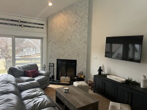 Cozy living room with wood burning fireplace and smart TV. Open living concept.