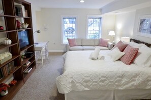 Looking back from kitchen across living / sleeping space. Comfortable couch beneath window