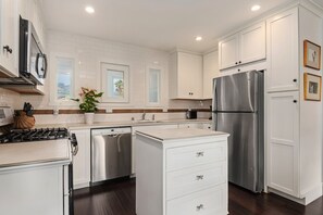 Kitchen view with stainless steel appliances and island.