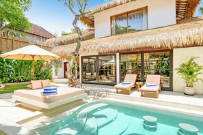 Elegant villa retreat with tranquil pool and lush surroundings.