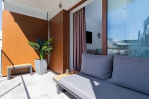 A private terrace or balcony furnished with modern seating and greenery, offering a cozy spot to relax outdoors.