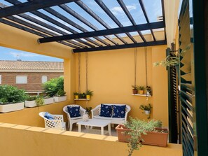 Upstairs Terrace with flowers and comfy chairs.