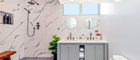 DOUBLE BATHROOM: Two showers with a teak stool and two sink vanity with mirrors.