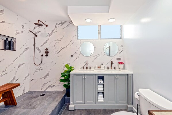 DOUBLE BATHROOM: Two showers with a teak stool and two sink vanity with mirrors.