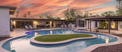 Resort style yard with lazy river pool, spa, putting green, BBQ grill, swim up bar, smart TV, covered patio, outdoor dining area, and MORE!