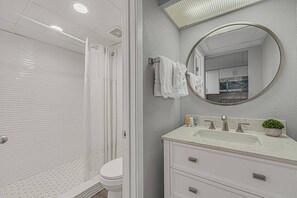 The bathroom features vanity sink, toilet and shower.