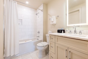 Ensuite Guest Bathroom featuring a bathtub and shower combination. Enjoy the plush white towels, standard size blow dryer and complimentary travel size shampoo, conditioner, body wash, tooth brushes (2), tooth paste, mouth wash, lotion and makeup remover wipes (3).