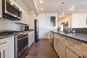 Cook and dine easily in the fully stocked kitchen, equipped with all stainless steel appliances, gas range, basic cookware, and a dining area for a comfortable meal at home. Entertain at the island with seating for four.