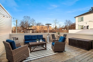 Our home's back patio/balcony, complete with overhead string lights, a propane heater, mini bar, and plenty of comfy seating!