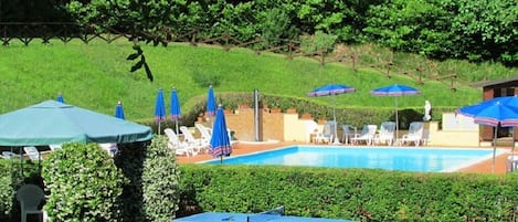 piscina con zona prato attrezzata con ping-pong e giochi per bambini