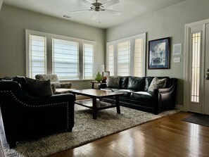 Well lit living room with plenty of seating available.