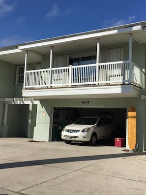 2 car Garage filled with beach accessories including paddleboard, chairs etc