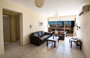 Living room with comfortable seating area widescreen TV and balcony