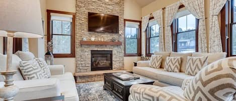 Family room with gas fireplace, mounted TV, and comfortable furniture
