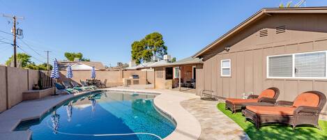 Private backyard with a pool, multiple seating areas, putting green, TV, BBQ grill, and yard games.