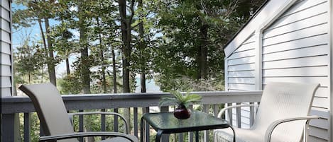 The balcony offers a table for two with a serene view of the lake.